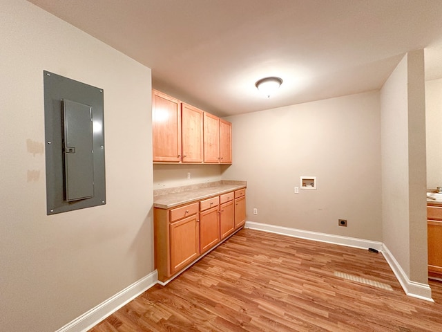 laundry room with cabinets, electric panel, hookup for a washing machine, electric dryer hookup, and light wood-type flooring