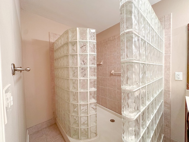 bathroom with tile patterned floors, vanity, and a tile shower