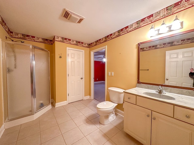 bathroom with vanity, a shower with shower door, tile patterned floors, and toilet