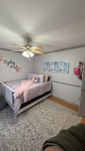 bedroom featuring light wood-type flooring, ceiling fan, and crown molding