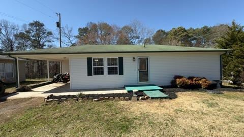 rear view of house with a carport, a lawn, and driveway