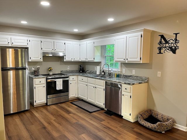 41 Magnolia Ct, Rydal, GA 30171 - kitchen with stainless steel appliances, under cabinet range hood, dark stone counters, dark wood-type flooring, and white cabinets