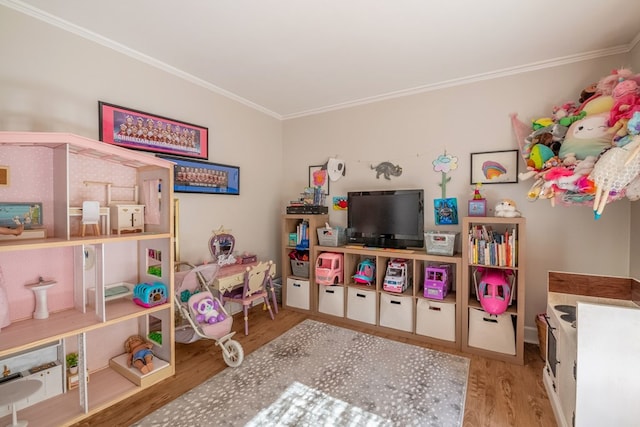 playroom with ornamental molding and light hardwood / wood-style flooring