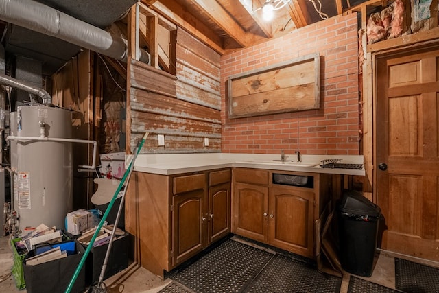 kitchen featuring secured water heater, sink, and brick wall