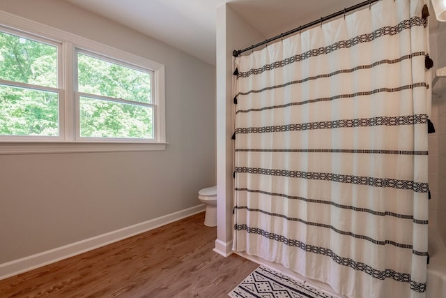 bathroom featuring a shower with curtain, toilet, and hardwood / wood-style floors