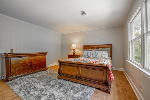 bedroom with crown molding and light hardwood / wood-style floors