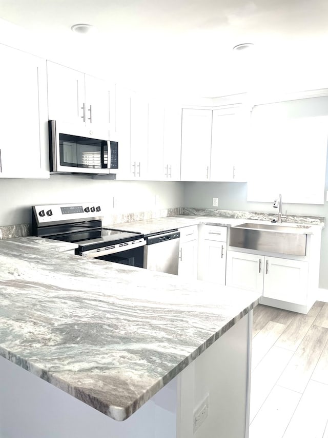 kitchen featuring white cabinetry, stainless steel appliances, and sink