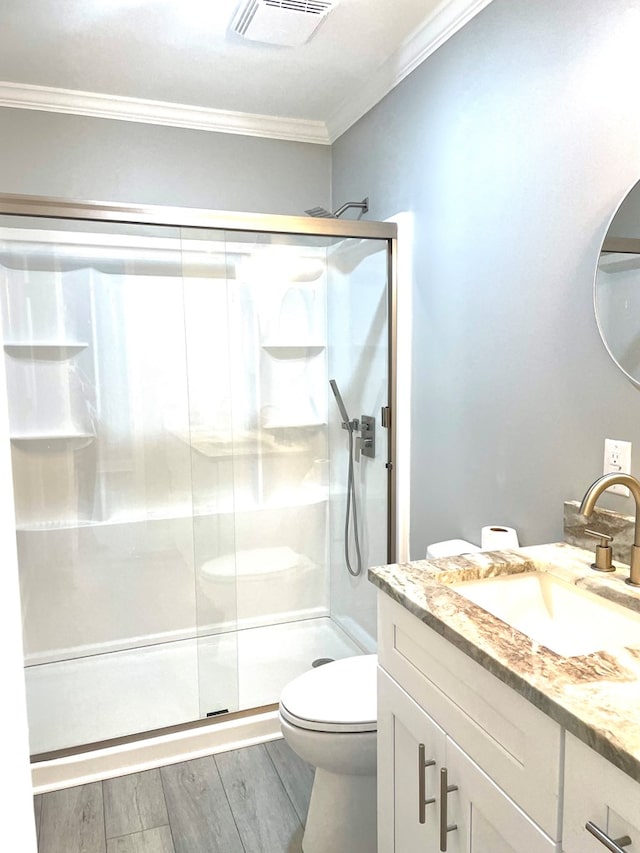 bathroom with hardwood / wood-style flooring, vanity, ornamental molding, toilet, and walk in shower