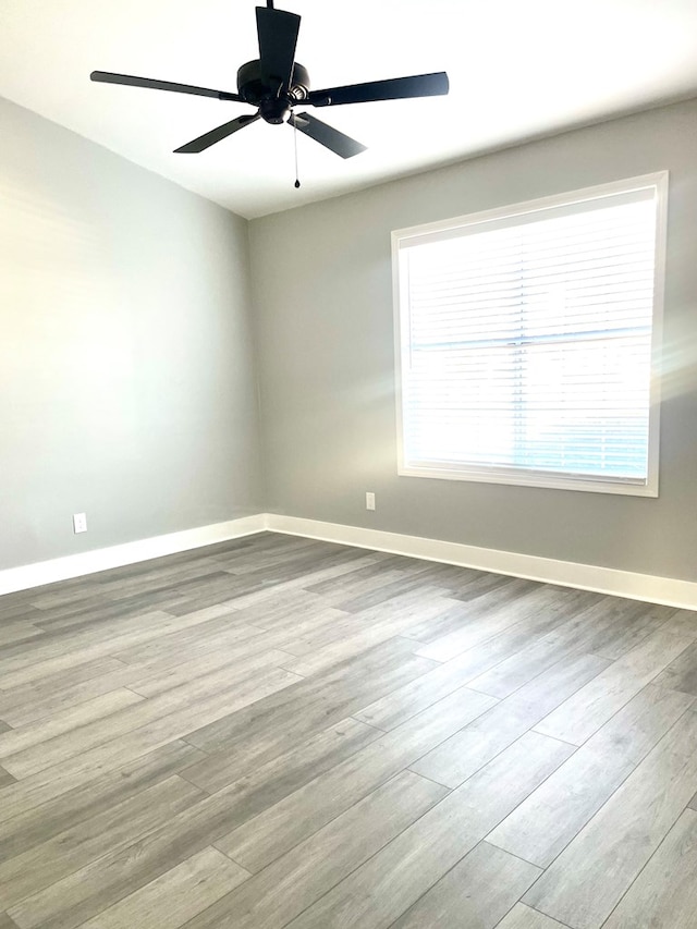 empty room with ceiling fan and light wood-type flooring