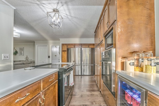 432 Castle Rd, Dalton, GA 30720 - kitchen with wine cooler, a textured ceiling, a notable chandelier, stainless steel appliances, and light hardwood / wood-style floors