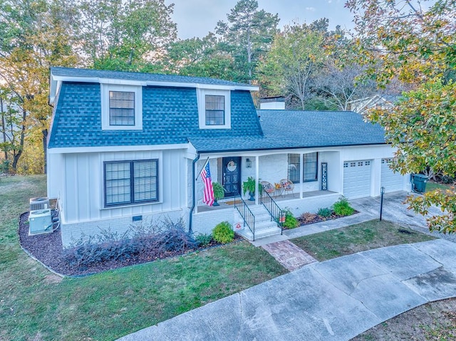 front of property with a porch, a garage, and a front yard