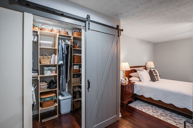 103 Paddle Wheel Ct, Cohutta, GA 30720 - bedroom featuring a barn door, wood finished floors, a textured ceiling, and a closet