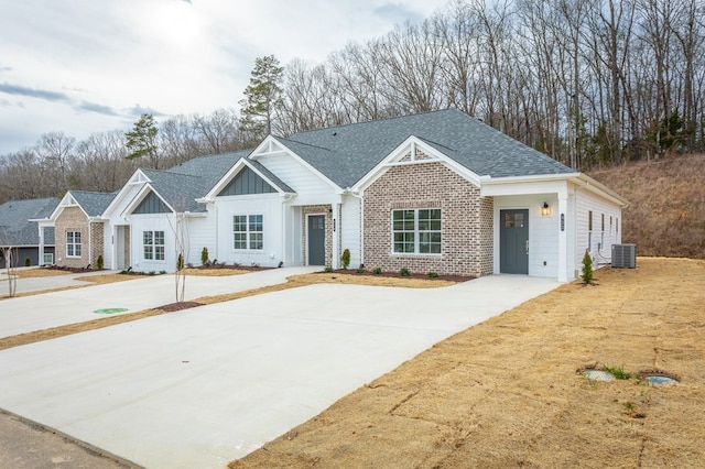 191 Andros Dr, Dalton, GA 30721 - view of front facade featuring cooling unit, board and batten siding, roof with shingles, and brick siding