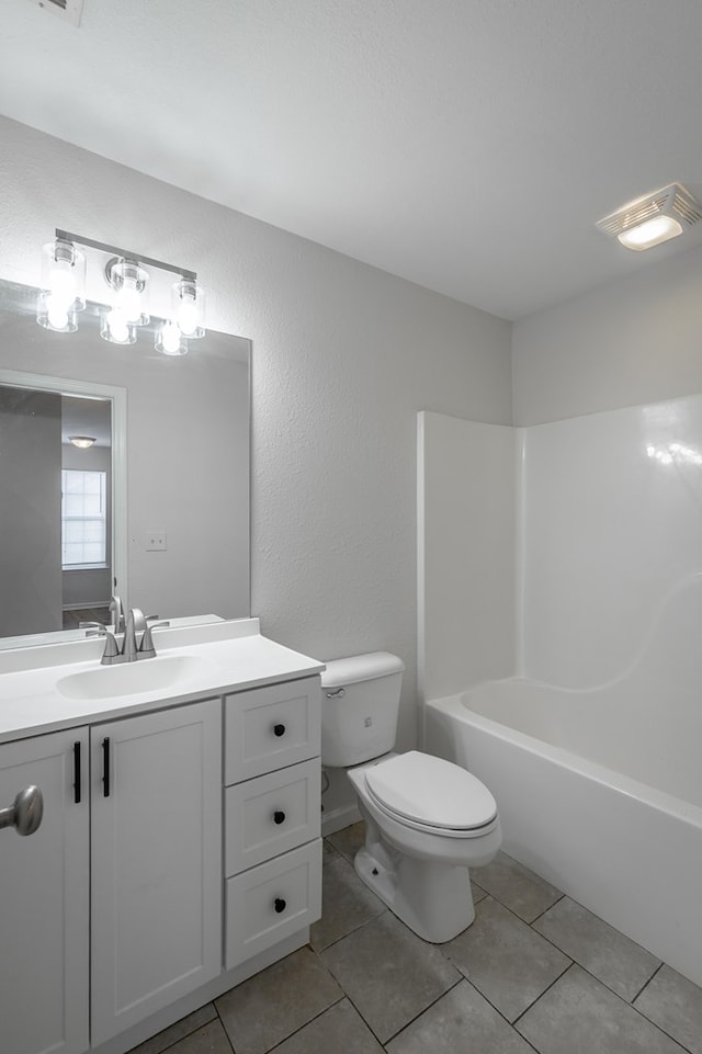 full bathroom featuring vanity, toilet,  shower combination, and tile patterned flooring