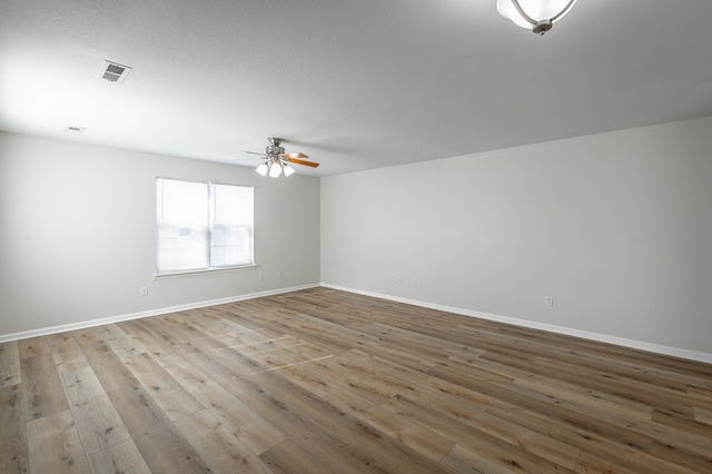 spare room featuring ceiling fan, a textured ceiling, and light wood-type flooring