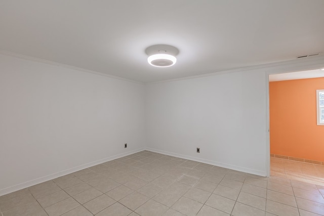 tiled spare room featuring crown molding