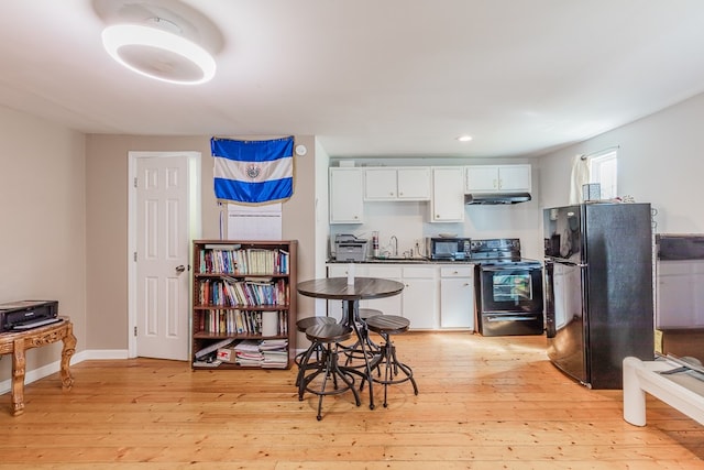 kitchen featuring sink, light hardwood / wood-style flooring, black appliances, and white cabinets