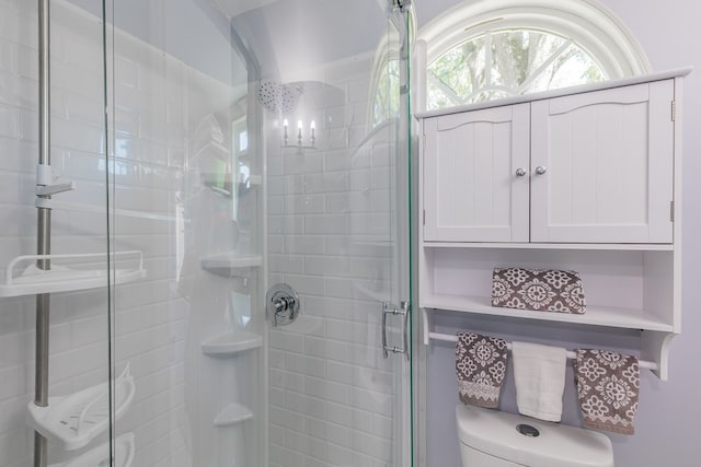 bathroom featuring toilet and an enclosed shower