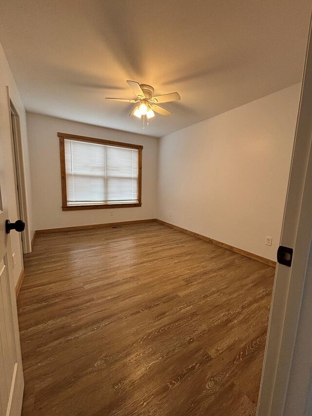 unfurnished room with ceiling fan and dark hardwood / wood-style floors