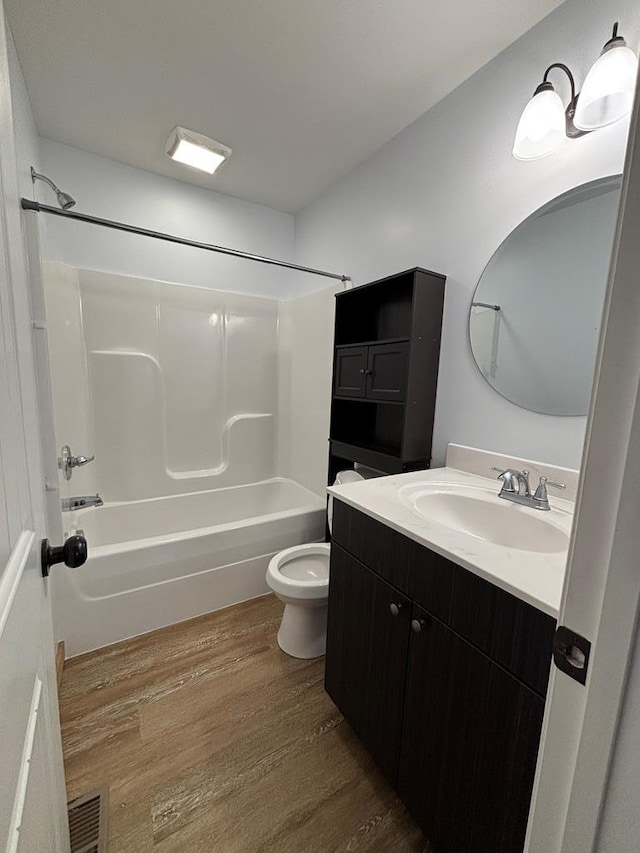 full bathroom with wood-type flooring, toilet, tub / shower combination, and vanity