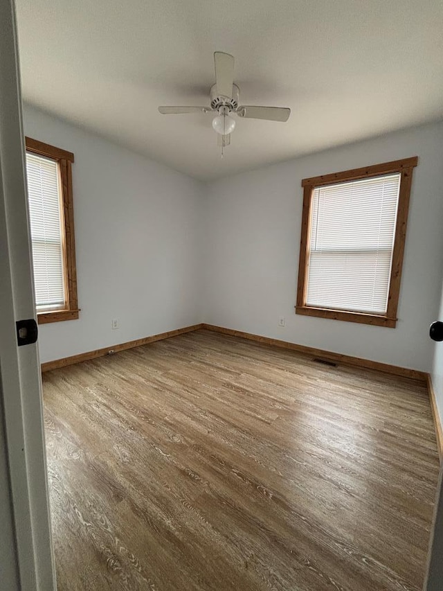 spare room with ceiling fan and light wood-type flooring