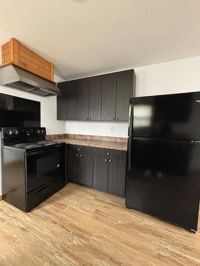 kitchen with light hardwood / wood-style flooring, ventilation hood, and black appliances