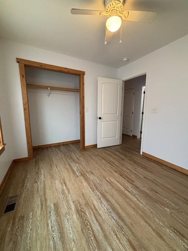 unfurnished bedroom featuring a closet, ceiling fan, and light wood-type flooring