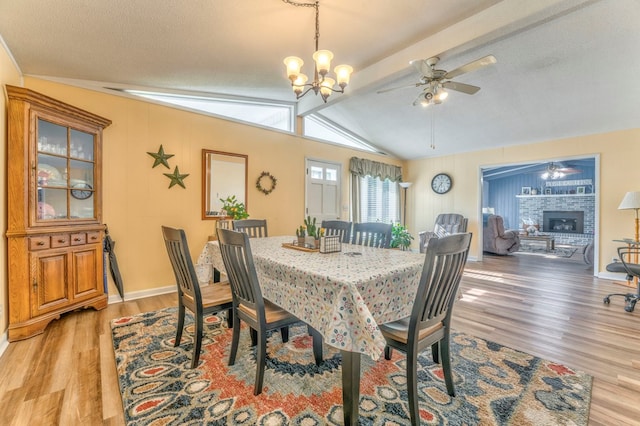 1164 Holly Grove Cir, Dalton, GA 30720 - dining room with ceiling fan with notable chandelier, lofted ceiling with beams, a fireplace with raised hearth, baseboards, and light wood-style floors