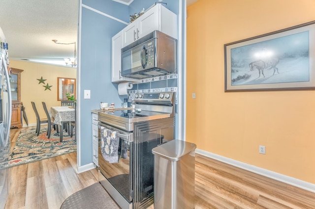 1164 Holly Grove Cir, Dalton, GA 30720 - kitchen with baseboards, stainless steel electric stove, white cabinetry, black microwave, and light wood-style floors