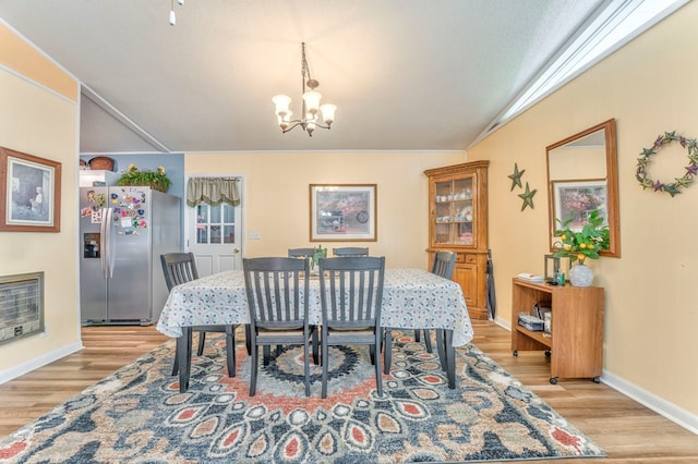 1164 Holly Grove Cir, Dalton, GA 30720 - dining area with a chandelier, light wood-style floors, vaulted ceiling, and baseboards
