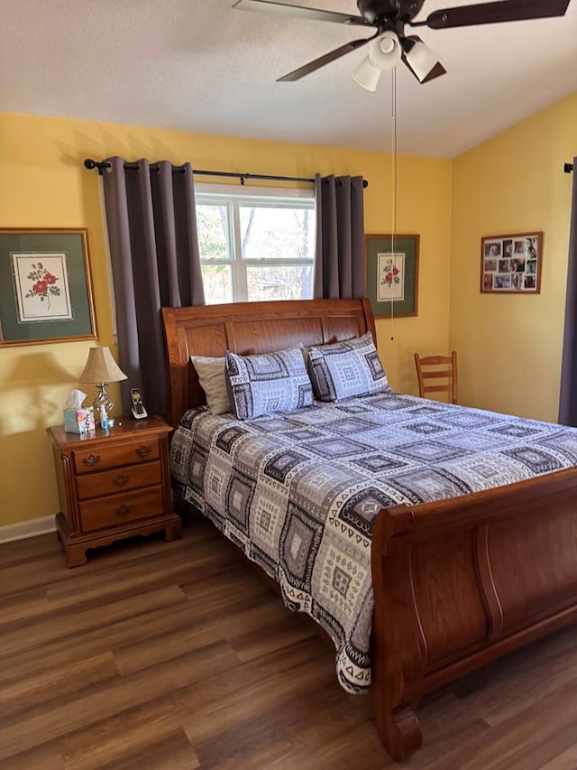 bedroom with baseboards, a ceiling fan, vaulted ceiling, and wood finished floors