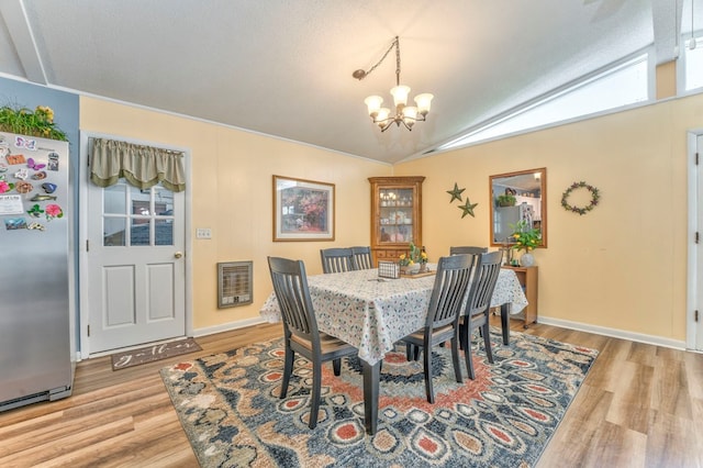 1164 Holly Grove Cir, Dalton, GA 30720 - dining space featuring lofted ceiling, light wood-style flooring, a notable chandelier, and baseboards