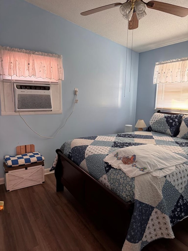 bedroom featuring a textured ceiling, cooling unit, a ceiling fan, and wood finished floors