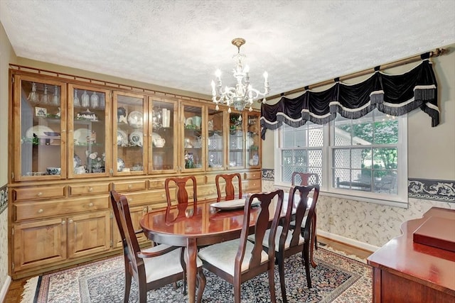 153 Buckingham Dr, Dalton, GA 30720 - dining room with a chandelier, a textured ceiling, baseboards, wallpapered walls, and wood finished floors