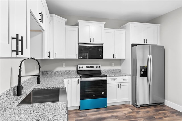 kitchen featuring stainless steel appliances, white cabinetry, sink, and light stone counters