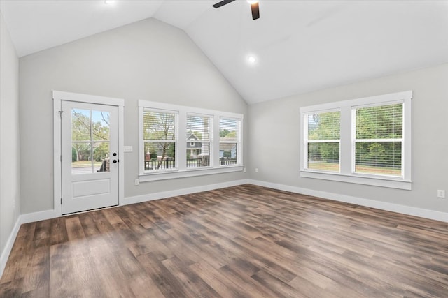 unfurnished living room featuring dark hardwood / wood-style flooring, a wealth of natural light, high vaulted ceiling, and ceiling fan