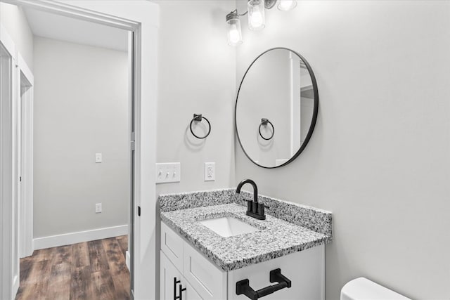 bathroom featuring hardwood / wood-style flooring, vanity, and toilet