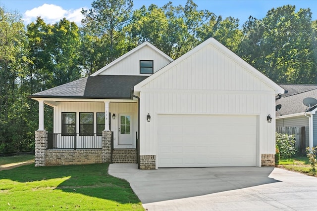 view of front facade featuring a garage, a front yard, and covered porch