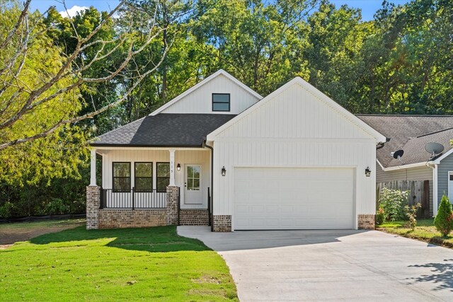 view of front facade with a garage, a front yard, and covered porch