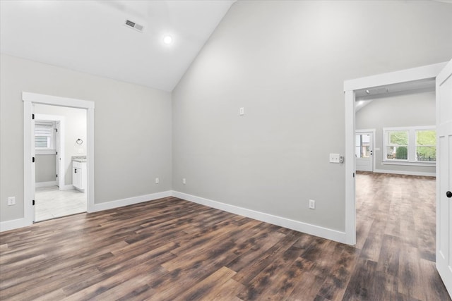 unfurnished room featuring dark wood-type flooring and high vaulted ceiling