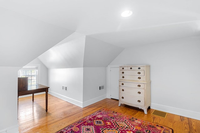 bonus room featuring lofted ceiling and light hardwood / wood-style flooring