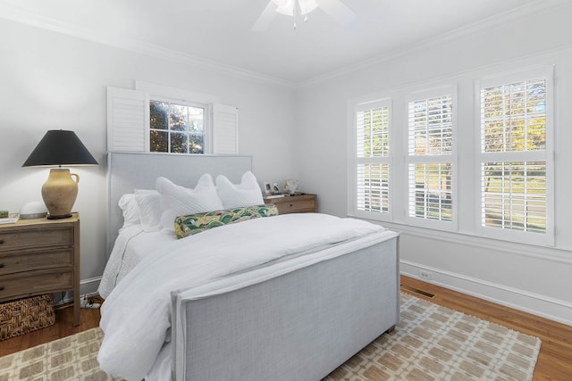 bedroom with ornamental molding, ceiling fan, and light wood-type flooring