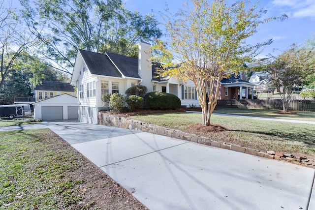 view of front of home with a garage, an outdoor structure, and a front lawn