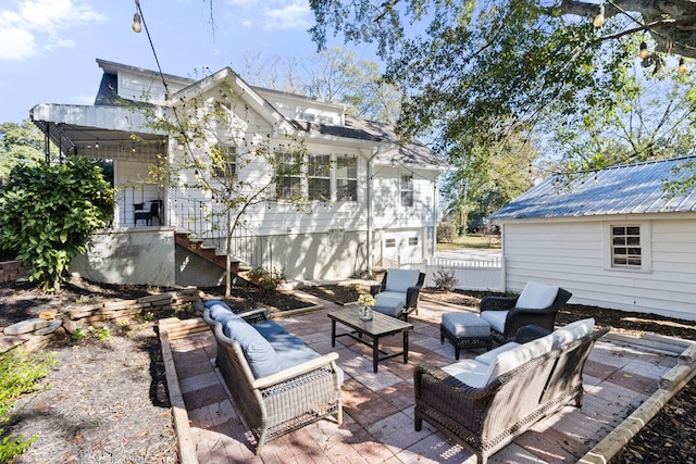 back of property featuring an outdoor structure, a patio, and an outdoor living space with a fireplace