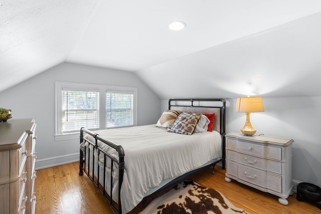 bedroom with lofted ceiling and hardwood / wood-style floors