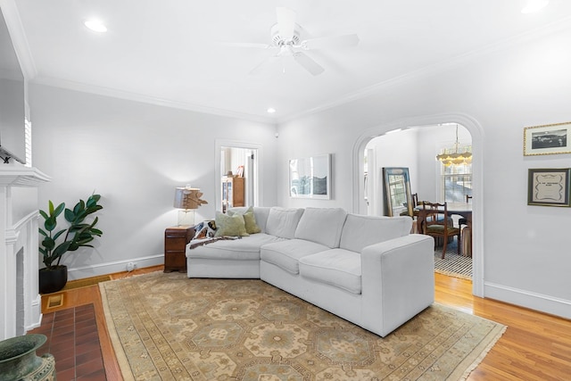 living room with crown molding, wood-type flooring, and ceiling fan with notable chandelier