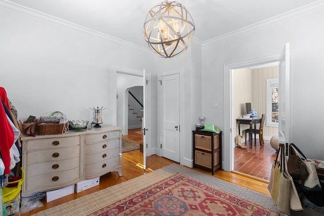 bedroom featuring ornamental molding, light hardwood / wood-style flooring, and a notable chandelier