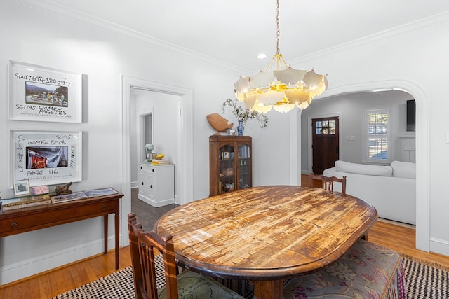 dining area featuring an inviting chandelier, crown molding, and wood-type flooring