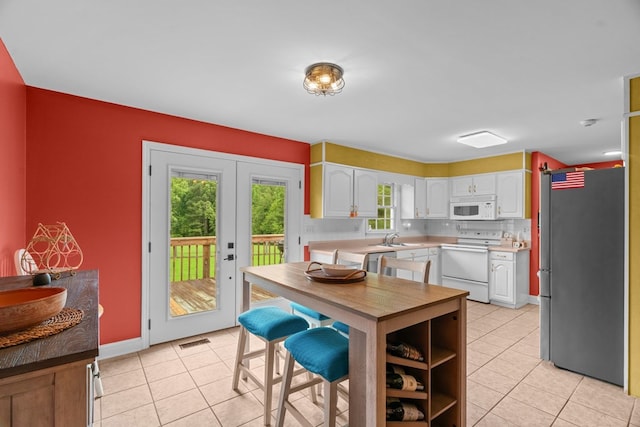 662 Nance Springs Rd, Dalton, GA 30721 - kitchen with stainless steel appliances, light tile patterned flooring, white cabinetry, light countertops, and tasteful backsplash