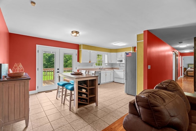 662 Nance Springs Rd, Dalton, GA 30721 - kitchen with appliances with stainless steel finishes, white cabinets, open floor plan, light countertops, and light tile patterned floors